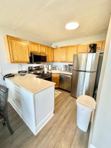 una cucina con mobili in legno e un frigorifero in acciaio inossidabile di Private Carolina Beach Retreat with Ocean Views! a Carolina Beach Altre 42 foto