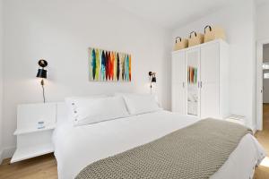 a white bedroom with a white bed and a white cabinet at Haven Tiny House - Pool, Walk to Downtown in St. Augustine