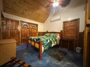 a bedroom with a bed and wooden walls and a ceiling at Howler Landing Vacation Rental in Bermudian Landing