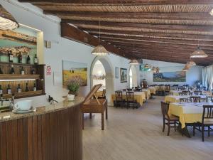 ein Restaurant mit Tischen und Stühlen und einem Speisesaal in der Unterkunft Agriturismo Scalelle in Otranto