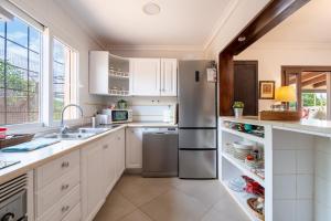 a kitchen with white cabinets and a stainless steel refrigerator at Alegrías in Pla de na Tesa