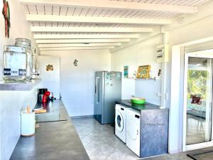 a kitchen with a refrigerator and a washing machine at Villa Tramontane. Vue mer. 2 chambres. Ferry Deshaies. in Deshaies +12 photos