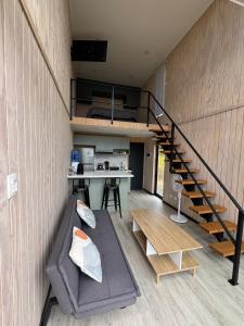 uma sala de estar com um sofá e uma escada em Refugio Matanzas Loft con Jacuzzi privado em Pupuya