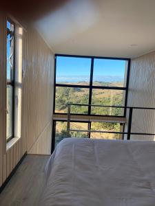 um quarto com uma cama e uma janela grande em Refugio Matanzas Loft con Jacuzzi privado em Pupuya