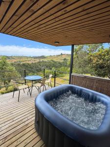 uma banheira de hidromassagem num deque com uma mesa e cadeiras em Refugio Matanzas Loft con Jacuzzi privado em Pupuya