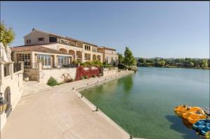 a house on the side of a river at Appartement Pont Royal vu lac in Mallemort