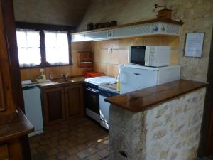 a small kitchen with a stove and a refrigerator at Le petit moulin in Journet