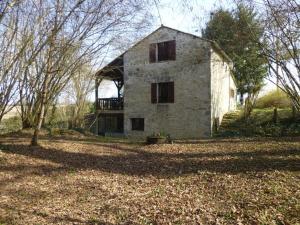 an old house in a field with trees in front of it at Le petit moulin in Journet