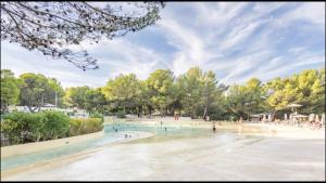 a rendering of a beach with people in the water at Appartement Pont Royal vu lac in Mallemort
