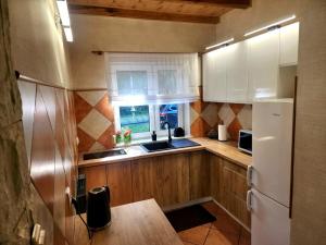 a kitchen with wooden cabinets and a white refrigerator at Nad Miedwinką - Dom in Morzyczyn