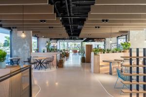 a restaurant with tables and chairs and windows at Student Experience Granada - Luxury Hostel in Granada