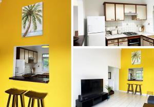 a kitchen and a living room with yellow walls at L'écrin des Salines, votre escale tropicale in Le Gosier