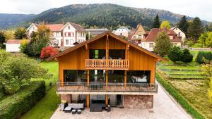 a house with a deck and a balcony at Aux mélèzes de Xavier GÎTE 4 étoiles in Wangenbourg