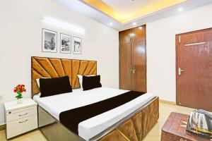 a bedroom with a large bed with a wooden headboard at Hotel O Yash stay in New Delhi
