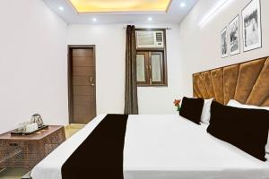 a bedroom with a large bed and a table at Hotel O Yash stay in New Delhi