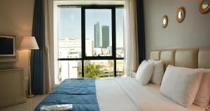 Un dormitorio con una cama con una ventana grande. en Amman West Luxury Hotel By Azar, en Amán