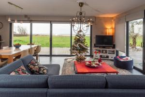 a living room with a blue couch and a christmas tree at La maison du bonheur in Riantec