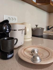 a kitchen counter with a coffee maker and a plate with a spoon at Cielo Cagliari For2 Design - Comfort Solo Adulti in Cagliari