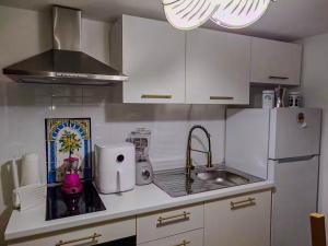 a white kitchen with a sink and a refrigerator at Casa Tre in Mussomeli