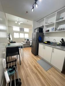 een keuken en een woonkamer met een tafel en een koelkast bij Holly's Place by Motorists Transient House in Biñan