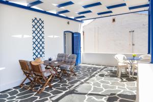 a room with a table and chairs and a blue ceiling at Olga's House Kythnos in Kithnos +17 photos