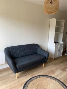 a black couch sitting in a living room at Charming House in Beauvais in Beauvais