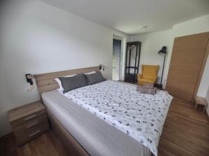 - une chambre avec un grand lit et une chaise jaune dans l'établissement Ta World apartments, 