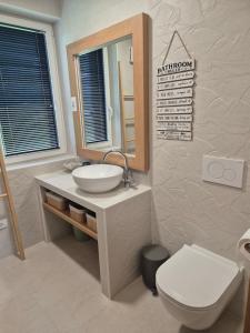 une salle de bain avec un lavabo, des toilettes et un miroir dans l'établissement Ta World apartments, 