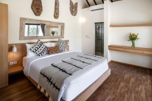 une chambre avec un grand lit blanc et une fenêtre dans l'établissement Center of Canggu - cute little villa - calm & quiet, à Canggu