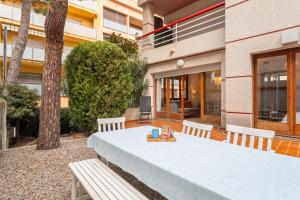 a table and bench in a courtyard with a building at Apartamento con Jardin y Parking in Platja  d'Aro