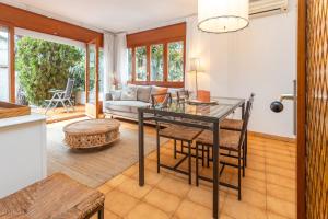 a kitchen and living room with a table and chairs at Apartamento con Jardin y Parking in Platja  d'Aro