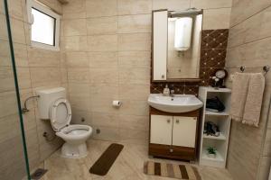 een badkamer met een toilet, een wastafel en een spiegel bij LuxuryHomeUlcinj in Ulcinj