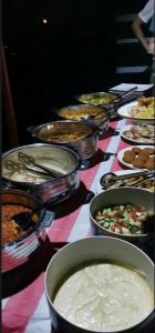 Al RakaにあるMirage Desert Campのさまざまな種類の食べ物が並んだテーブル
