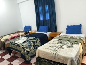 Habitación con 2 camas y almohadas azules. en Djorff Guest House, en Luxor 35 fotos más