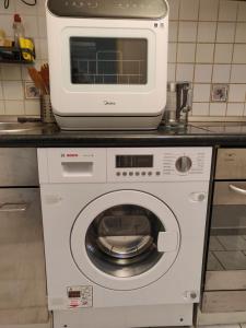 a microwave on top of a washing machine in a kitchen at Charming Room in a Central Location with perfect Connectivity in Munich