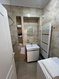 a bathroom with a sink and a mirror at Prenociste-apartmani Laki S in Kula +13 photos