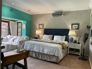 a bedroom with two beds and a table with a desk at The Ridgeback, 4 Bedroom Good Living, Bryanston in Johannesburg +38 photos