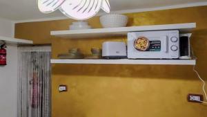 a microwave sitting on a shelf in a kitchen at Casa Tre in Mussomeli +3 photos