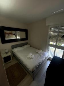 カステルデフェルスにあるOcean View Sunny Beach Apartment Castelldefelsのベッドとタオル2枚のある寝室 +2枚の写真