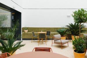 Un patio con mesa y sillas y plantas. en Atipico Madrid, en Madrid