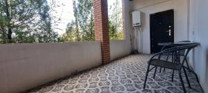 Tskhaltubo Spa Resort Apartments في Itʼkhvisi: كرسي أسود يجلس على الشرفة مع طاولة