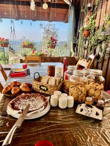 a table topped with a pizza and various types of bread at Alba di Montanaria in Brosso