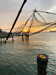 una red en el agua con gente de pie en un muelle en The Boho Stays Kochi, en Kochi