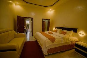a bedroom with a large bed and a couch at Murugano Village Hotel in Taba