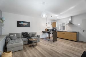 een woonkamer met een bank en een keuken bij 4 Apartamentos Omanai Tenerife Sur in Las Galletas