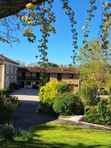 a building with a yard with grass and trees at Le Clairat in Saint-Michel-Saint-Jaymes