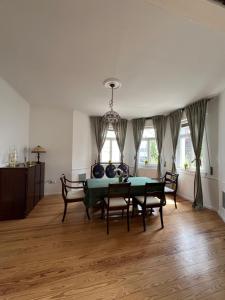 ein Esszimmer mit einem grünen Tisch und Stühlen in der Unterkunft Altbauvilla im Herzen von Lorsch in Lorsch