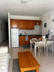 a kitchen with a table and a white refrigerator at Apartamento céntrico en Playa de Las Américas in Costa de Adeje