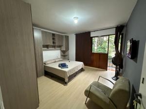 a bedroom with a bed and a chair in it at Quartos Vila Olímpia 1 in Sao Paulo