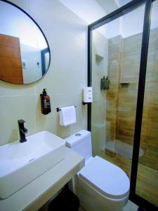 een badkamer met een wastafel, een toilet en een spiegel bij Hotel Costa Arena in Supe